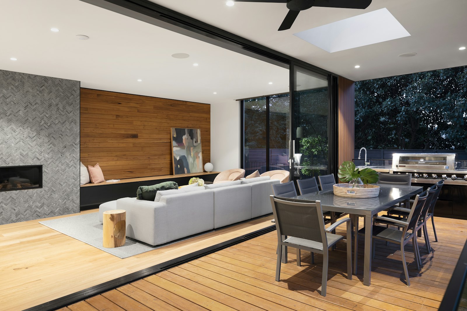 Offener Wohnbereich aus Holz mit großer Glasfront