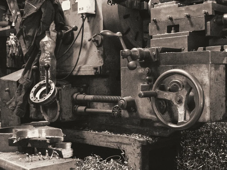 Alte Metalldrehbank mit Spaenen auf der Werkbank