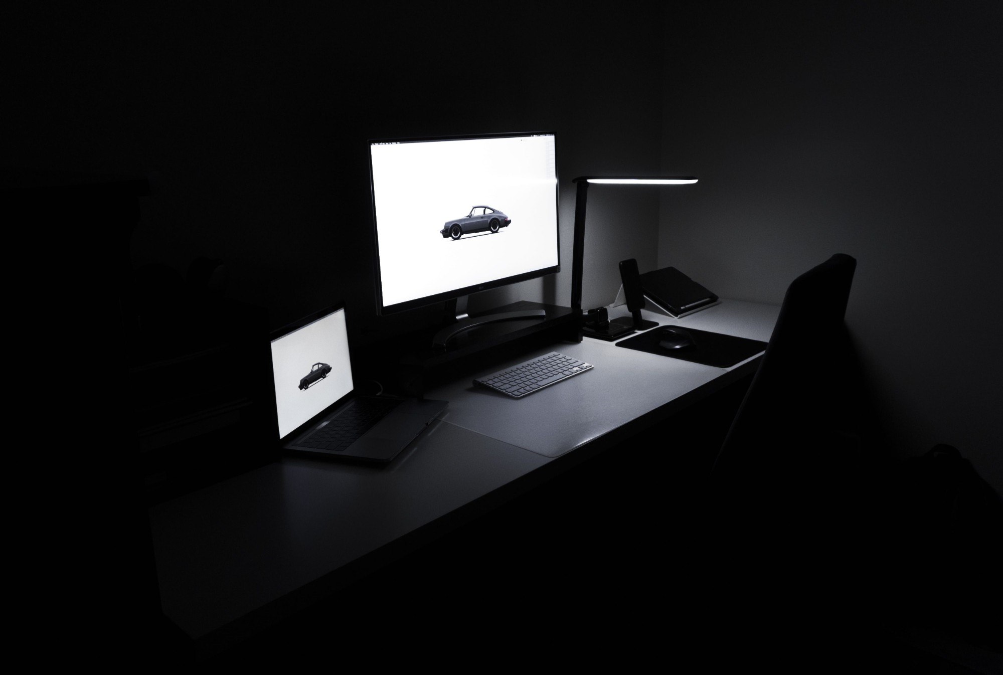 Dunkler Schreibtisch-Setup mit Monitor